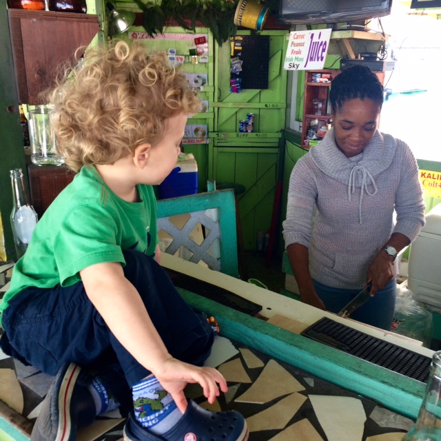 Child watches conch salad vendor on Potter's Cay, Bahamas